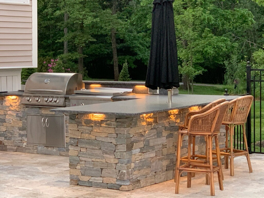 Custom outdoor kitchen, patio, stone walls, landscape lighting, steps and paths.